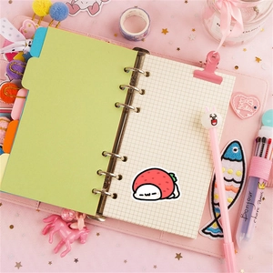 Detail of pink 6-ring binder notebook with strawberry sticker and cute stationery
