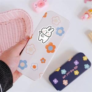 Close-up of pink and blue floral cartoon rabbit glasses cases on a decorated table