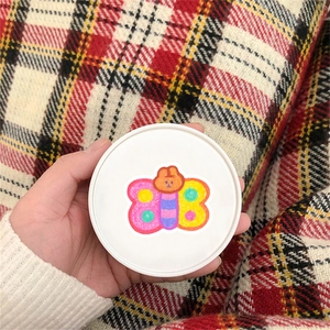 Macro shot of a cute butterfly sticker with colorful wings on a white round lid