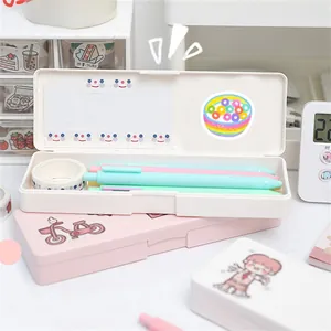 Pink and white aesthetic pencil cases with cute stickers holding macaron pens and washi tape
