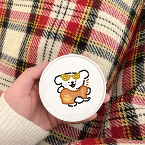Dettaglio di un contenitore rotondo bianco con una simpatica illustrazione di un cane