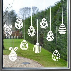 Nahaufnahme weißer Ostereier-Fensteraufkleber mit Hasen- und Blumenmustern auf Glas