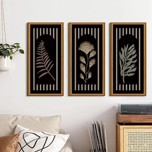 Three-piece set of Nordic geometric wooden wall art with leaf patterns over a sofa