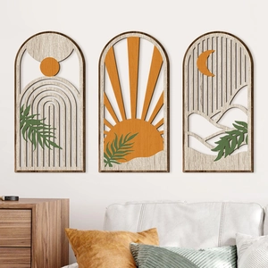Detail of laser-cut wooden arch wall art featuring sun and palm leaf boho patterns