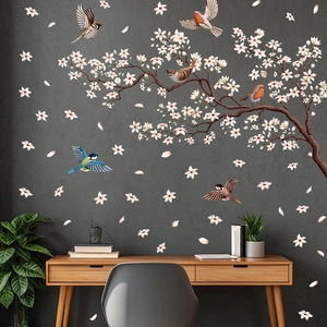 Peachy blossom tree branch wall decal with hummingbirds on a dark gray wall