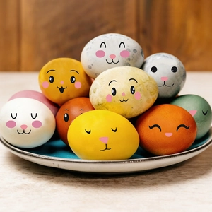 Colorful Easter egg stickers with cute cartoon animal faces on a white ceramic plate