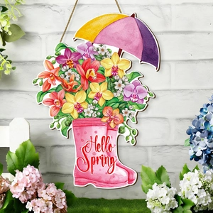 Detail of Hello Spring wooden sign featuring floral rain boots and umbrella on a rustic wall