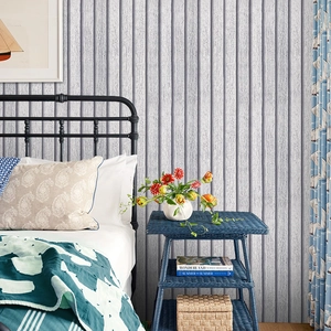 Detailed view of grey vertical wood grain wallpaper in a modern bedroom setting