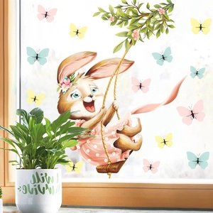 Close-up of decorative Easter bunny and butterfly window stickers on a glass surface