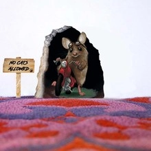 Macro detail of 3D mouse on red motorcycle wall sticker with No Cats Allowed sign