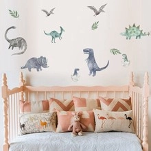 Detail view of dinosaur watercolor wall stickers set above a baby crib in a nursery