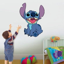 Child touching a large 3D Stitch wall decal sticker in a cozy nursery room setting