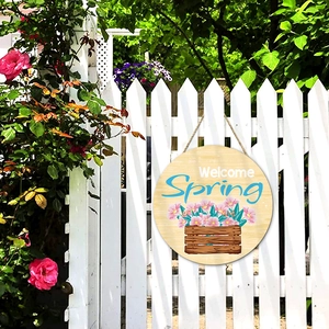 Spring welcome wooden round sign with pink flower illustration on a white fence