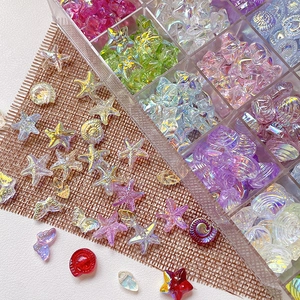 Iridescent glass beads set with starfish shell shapes in a clear storage organizer box