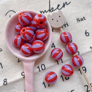 Macro detail of red and purple striped round beads for DIY handmade jewelry crafts