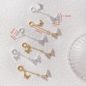 Detalle del colgante de mariposa en oro de 14k con circonitas sobre fondo blanco