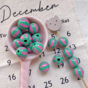 Detail of green and pink watermelon striped round resin beads for DIY jewelry making