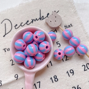 Macro view of pink and blue striped acrylic round beads for DIY jewelry making
