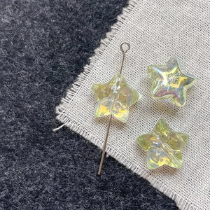Macro shot of iridescent starfish glass beads on burlap for DIY jewelry making