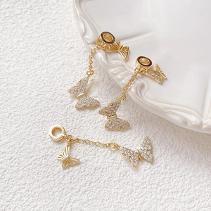 Detalle macro de cadena de extensión mariposa en oro de 14k con circonitas cúbicas