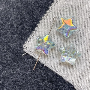 Macro shot of iridescent glass star beads with AB coating and silver metal pin for DIY jewelry