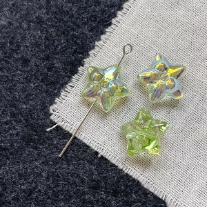 Macro view of light green star-shaped glass beads with iridescent AB coating and drill hole