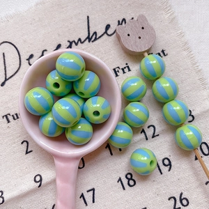 Macro shot of green and blue striped round beads for DIY handmade jewelry crafts