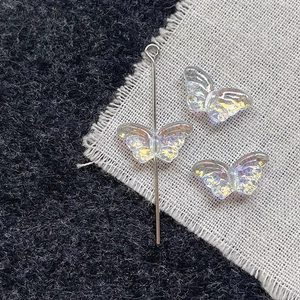 Detailed view of iridescent butterfly glass beads with vertical drill hole for DIY jewelry