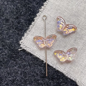 Macro shot of butterfly-shaped iridescent glass beads for DIY jewelry making and craft projects