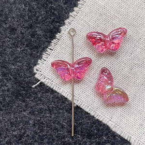 Detailed close-up of pink iridescent butterfly glass beads for DIY jewelry making
