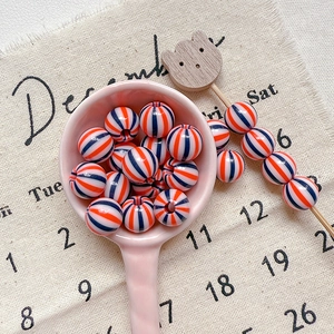 Detail of colorful striped acrylic beads in a ceramic spoon for DIY jewelry crafts