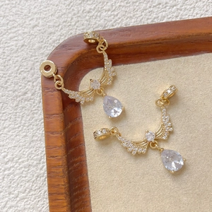 Dettaglio di connettori ali d'angelo placcati oro 18k con zirconi lucenti per gioielli DIY