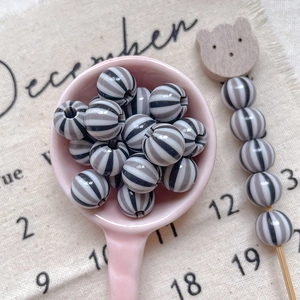 Close-up of black and white striped round resin beads for DIY jewelry making and crafts