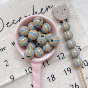 Detailed macro view of colorful striped acrylic round beads for DIY handmade jewelry crafts