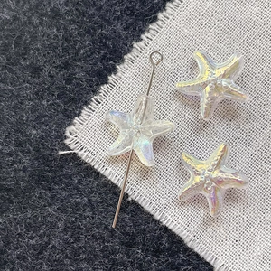 Macro shot of iridescent starfish glass beads on silver pins for DIY jewelry making