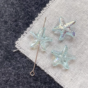 Macro detail of iridescent blue starfish glass beads with hole for DIY jewelry making