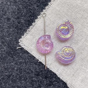 Macro view of iridescent purple glass nautilus beads for DIY jewelry making and craft