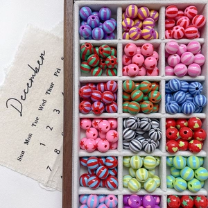 Detailed overhead view of colorful striped, heart, and star beads in a wood organizer box