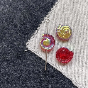 Macro shot of colorful glass snail beads with spiral texture and clear glass finish