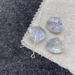Macro shot of iridescent scallop shell glass beads with pre-drilled holes for DIY jewelry