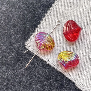 Macro detail of iridescent shell-shaped glass beads for DIY jewelry with silver pin