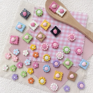 DIY strawberry and flower resin beads in macaron colors on a checkered background