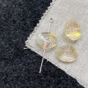 Detail of seashell glass beads with iridescent AB coating on textured fabric background