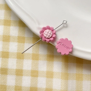 Detailed macro of pink resin daisy charm bead with flower engraving for DIY jewelry making