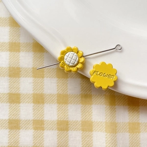 Macro shot of yellow sunflower beads with flower engraving for DIY jewelry crafting