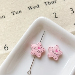 Détail de perles étoiles en émail rose avec texte Smile pour création de bijoux