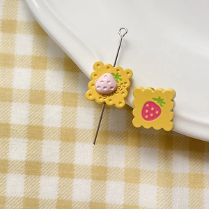 Macro detail of yellow strawberry cookie resin charms for DIY handmade jewelry