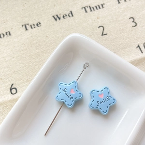 Vue macro de perles étoiles bleues avec cœurs roses et texte Smile pour bijoux DIY