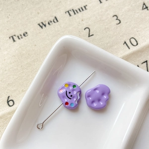 Vue macro de perles violettes avec sourire pour création de bijoux DIY sur céramique
