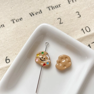 Gros plan de charms en résine en forme de biscuits avec sourire pour bijoux DIY